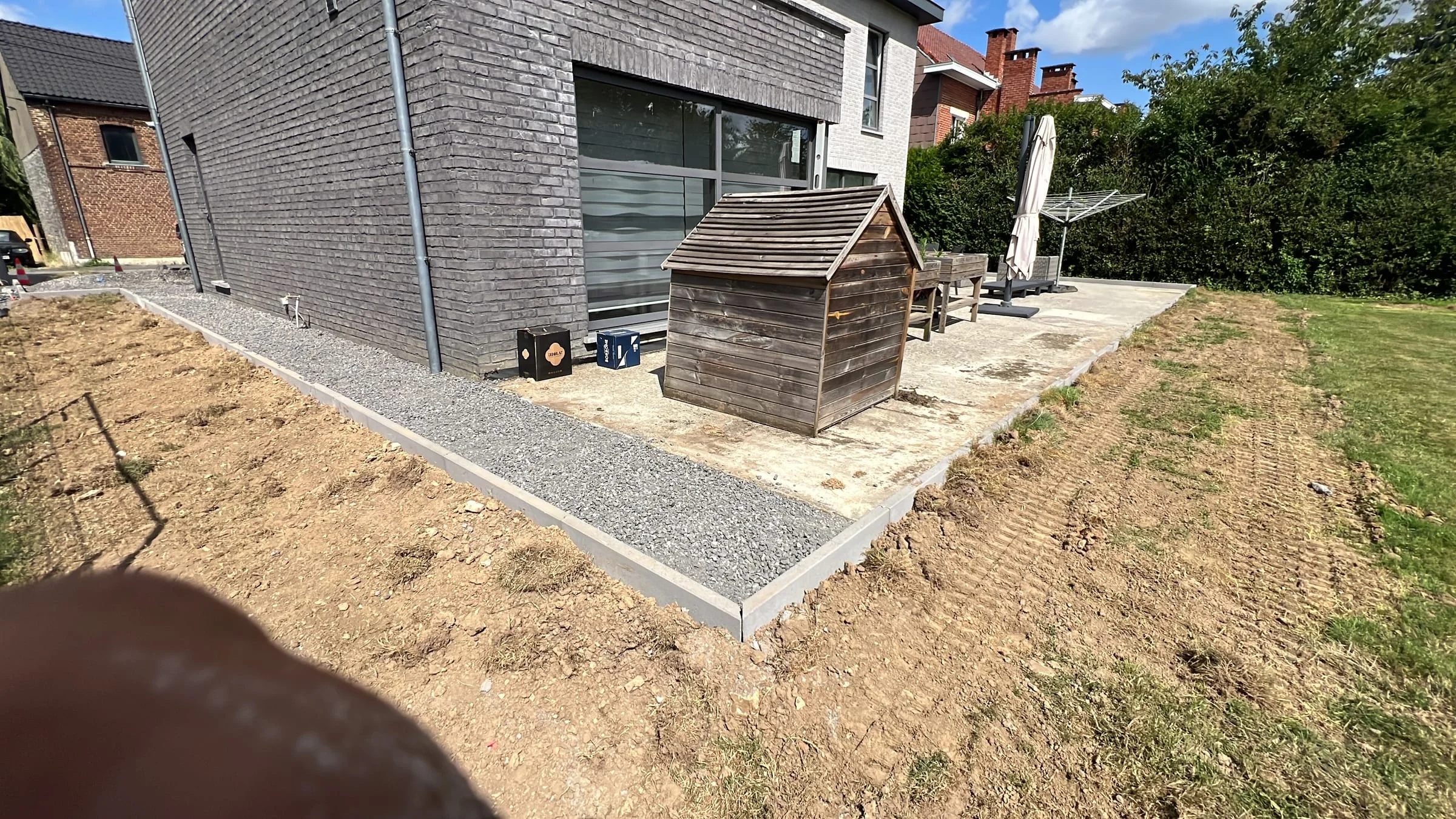 Préparation des bordures et du terrain autour de la terrasse avant la pose des revêtements