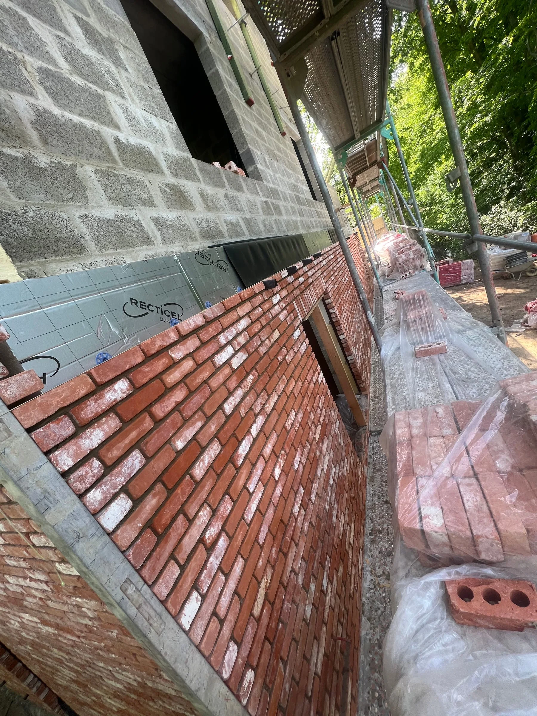 Détail de la pose du parement en briques le long d’une façade