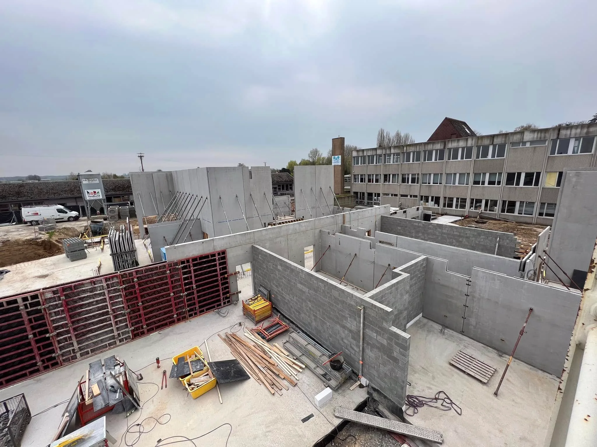 Vue générale du chantier de l’école avec les murs en béton et les cloisons intérieures