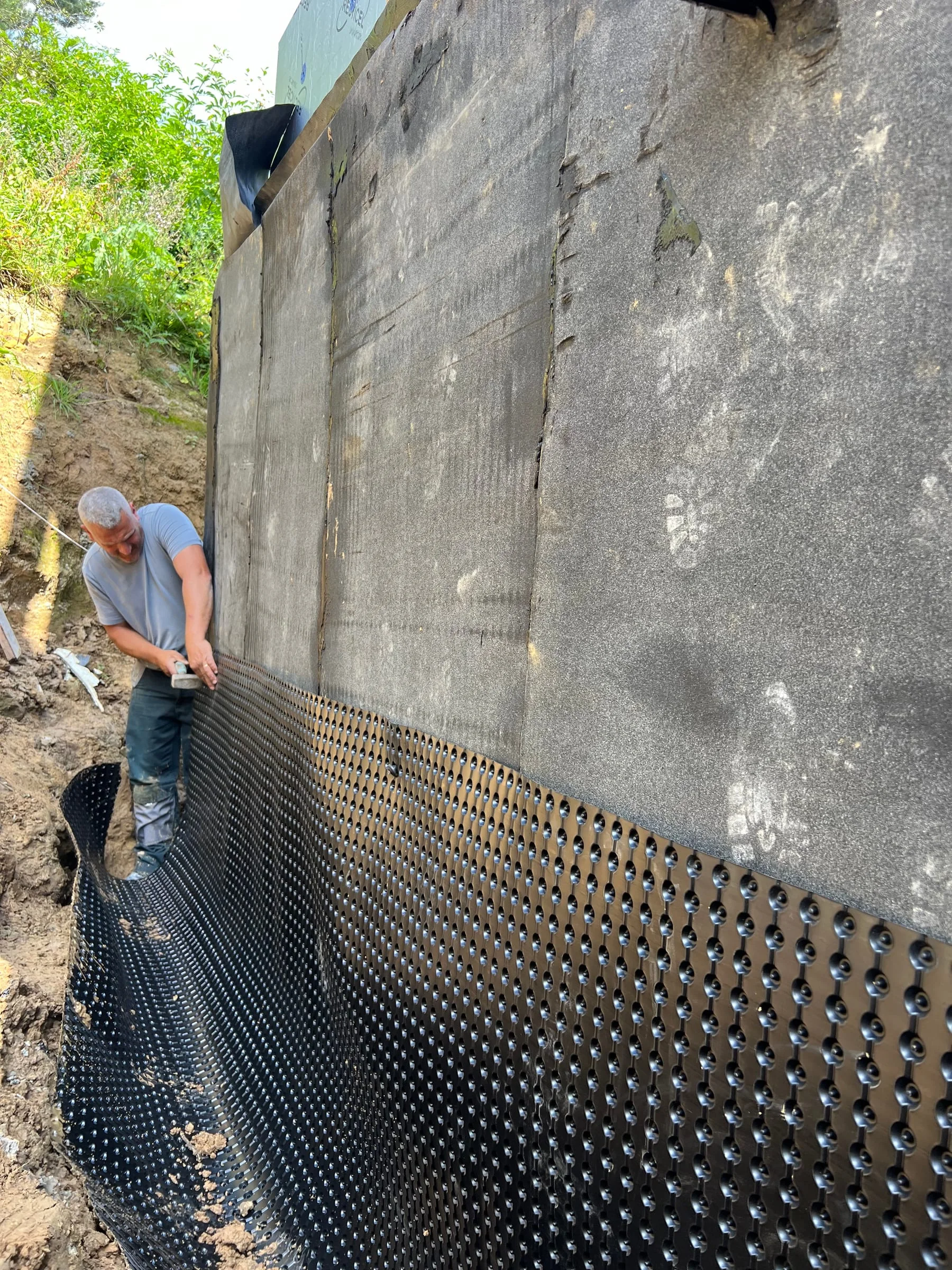 Pose d’une membrane drainante sur un mur enterré