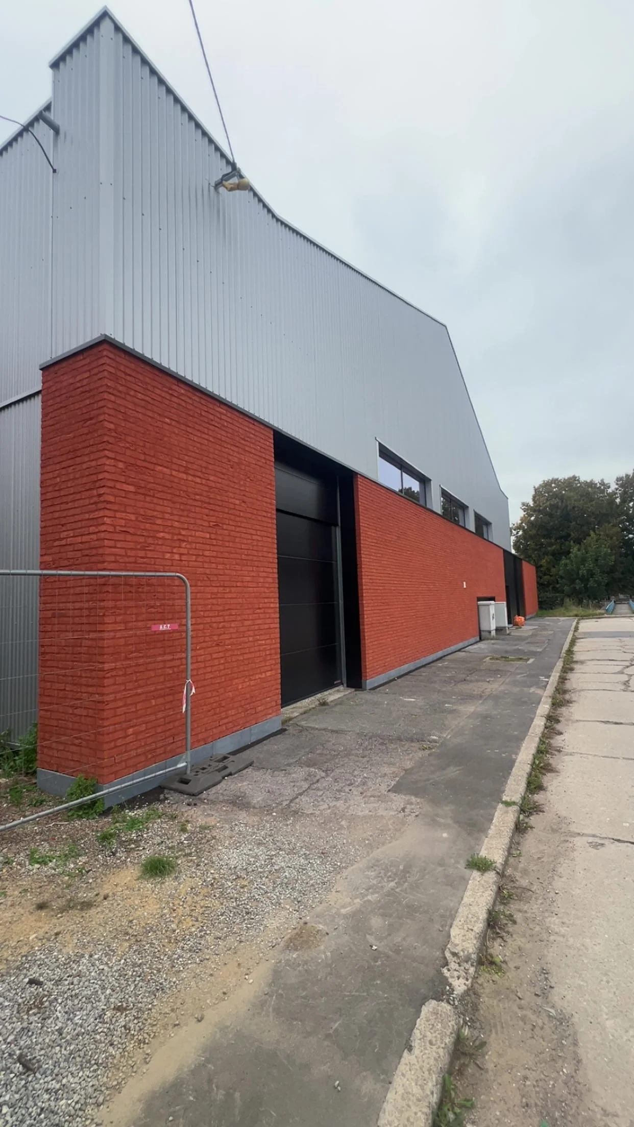 Façade rénovée avec parement en briques, bardage clair et grande ouverture