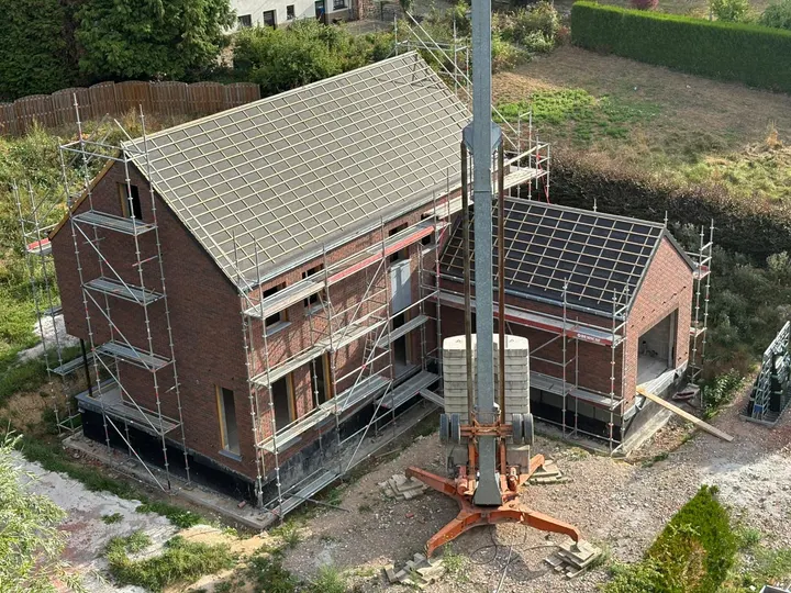 Vue aérienne de la maison en briques sous toiture avec les échafaudages