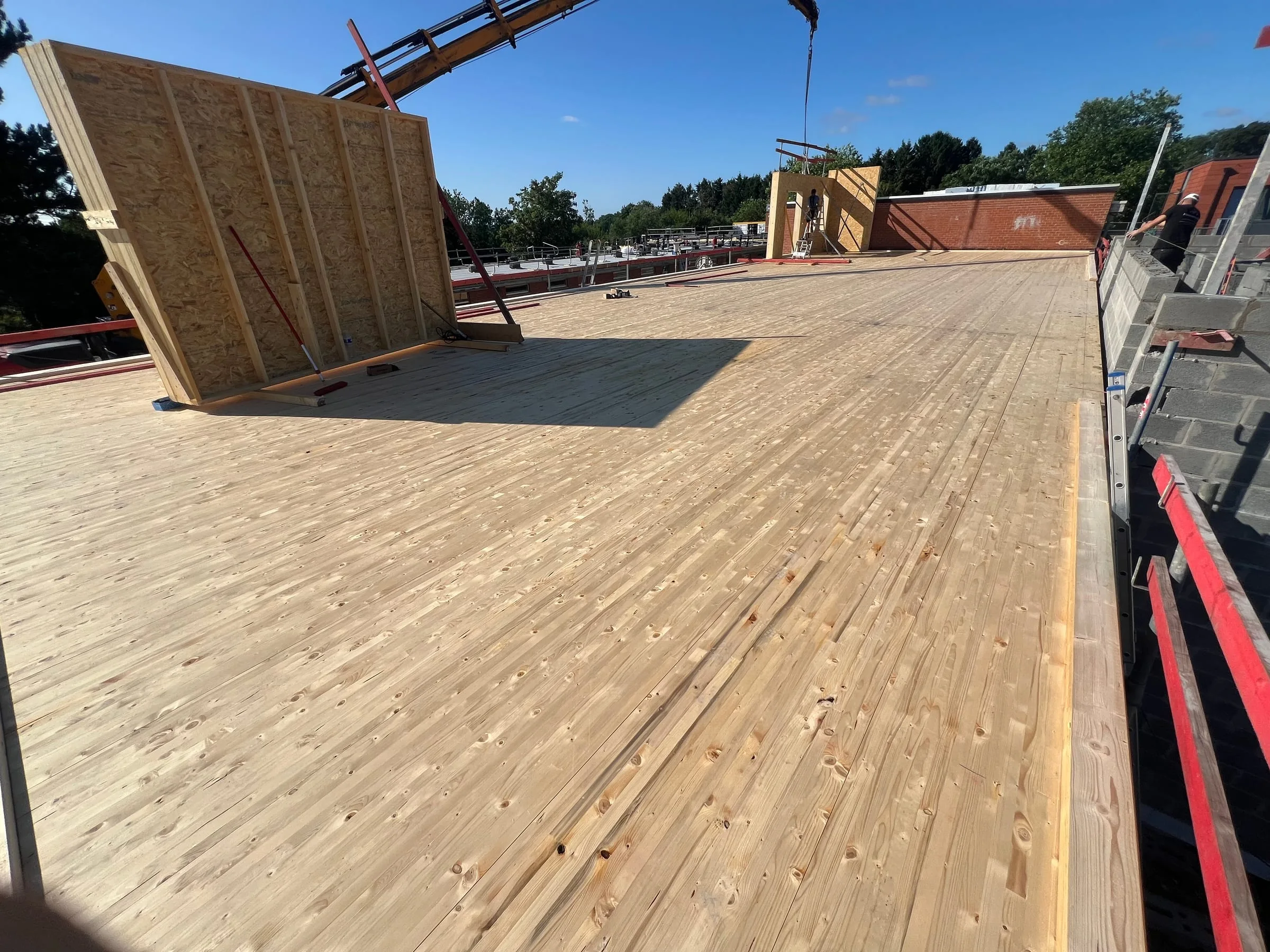 Nouveau plancher en bois et premiers panneaux d’ossature sur le bâtiment