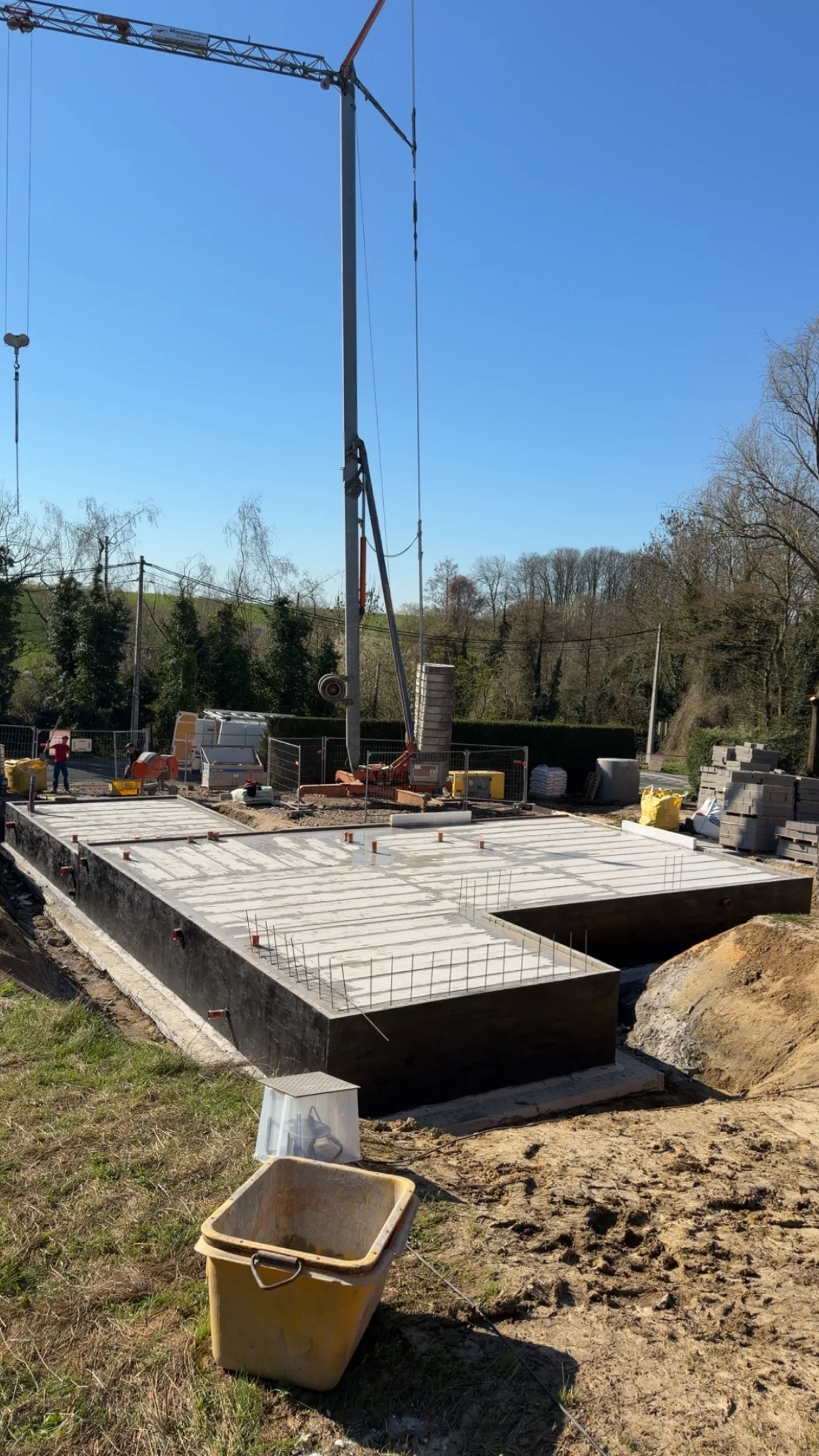 Plancher posé sur les murs de soubassement avec la grue en arrière-plan