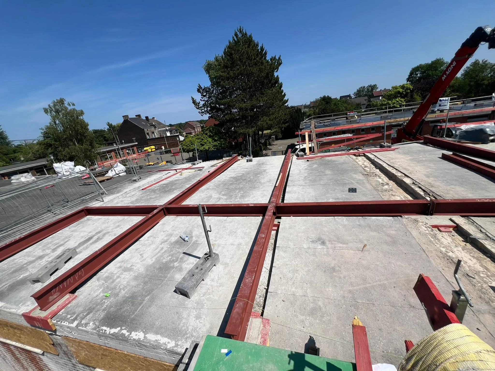 Profilés métalliques rouges répartis sur la toiture existante