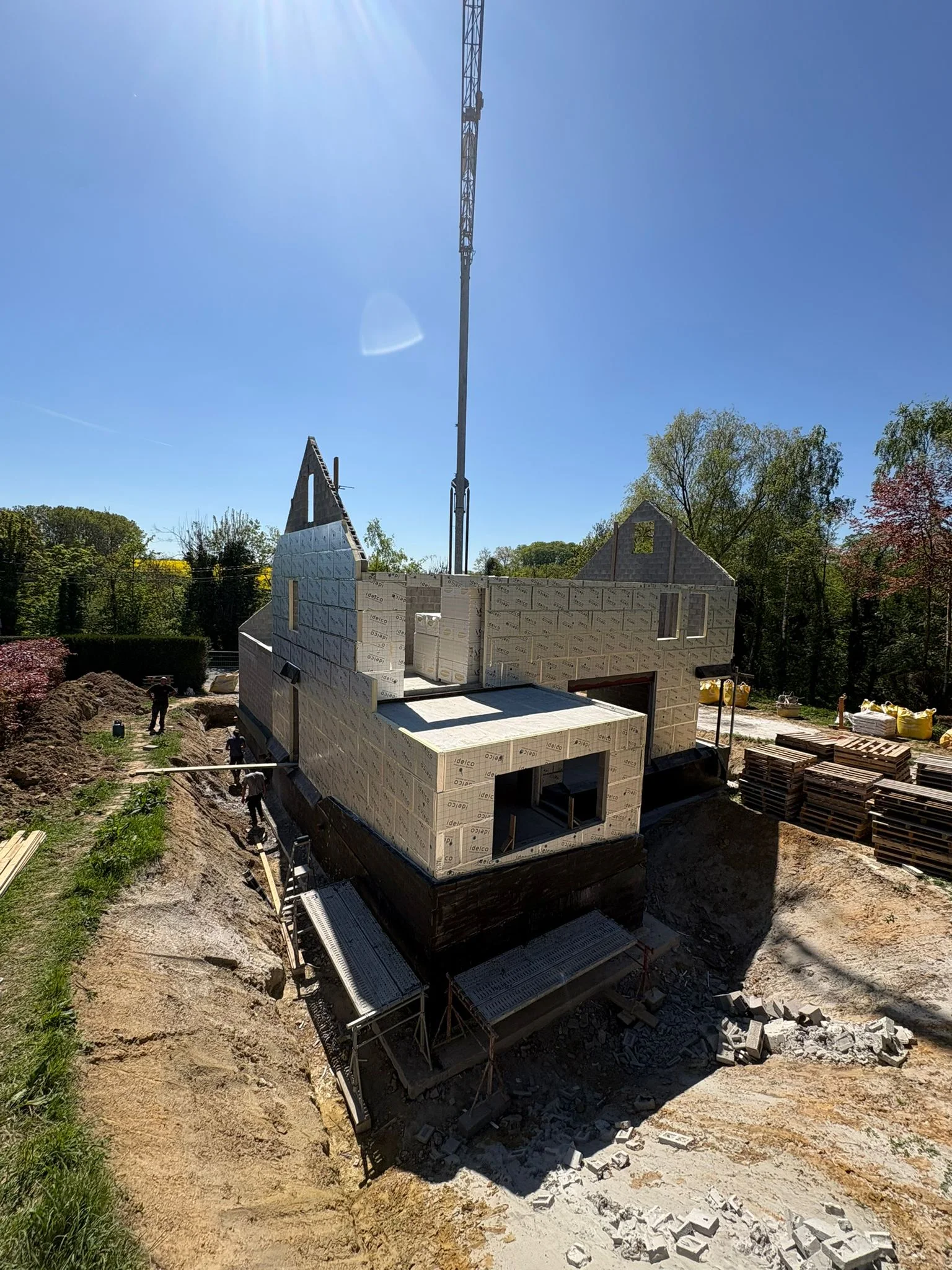 Façade en blocs et volume annexe avec la grue du chantier