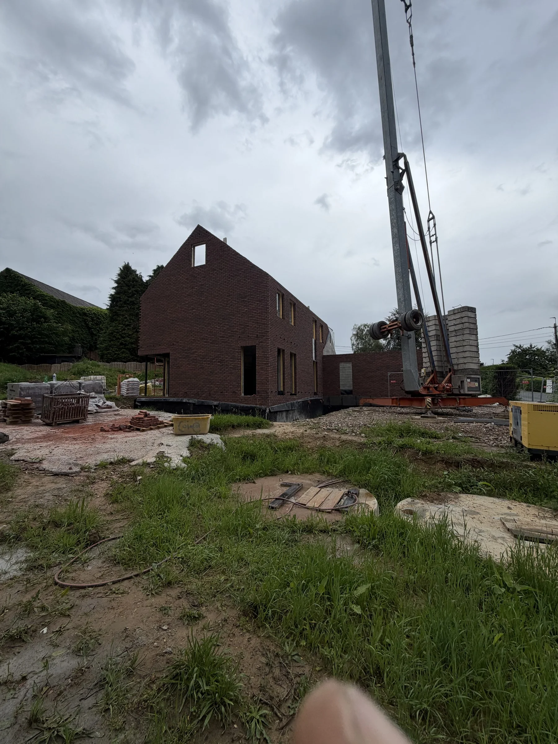 Pignon en briques et travaux de toiture en cours avec la grue