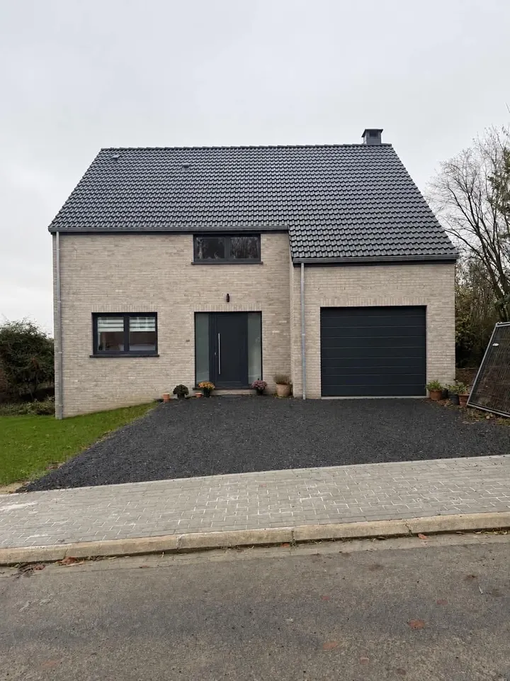 Vue depuis la rue de la maison terminée sur son terrain à double niveau